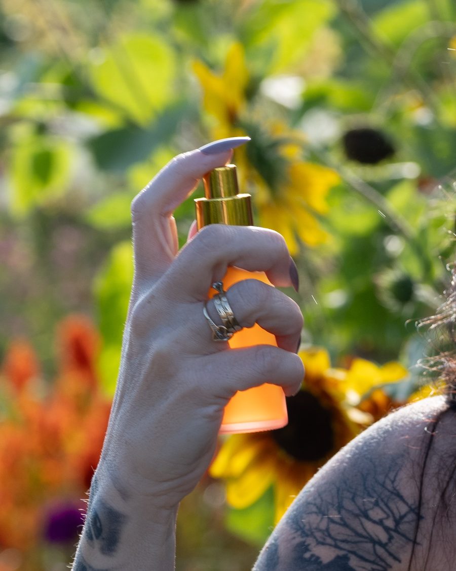 Vaporisation de la lotion tonique Lotus Solaire de B&F Essence parmi les tournesols
